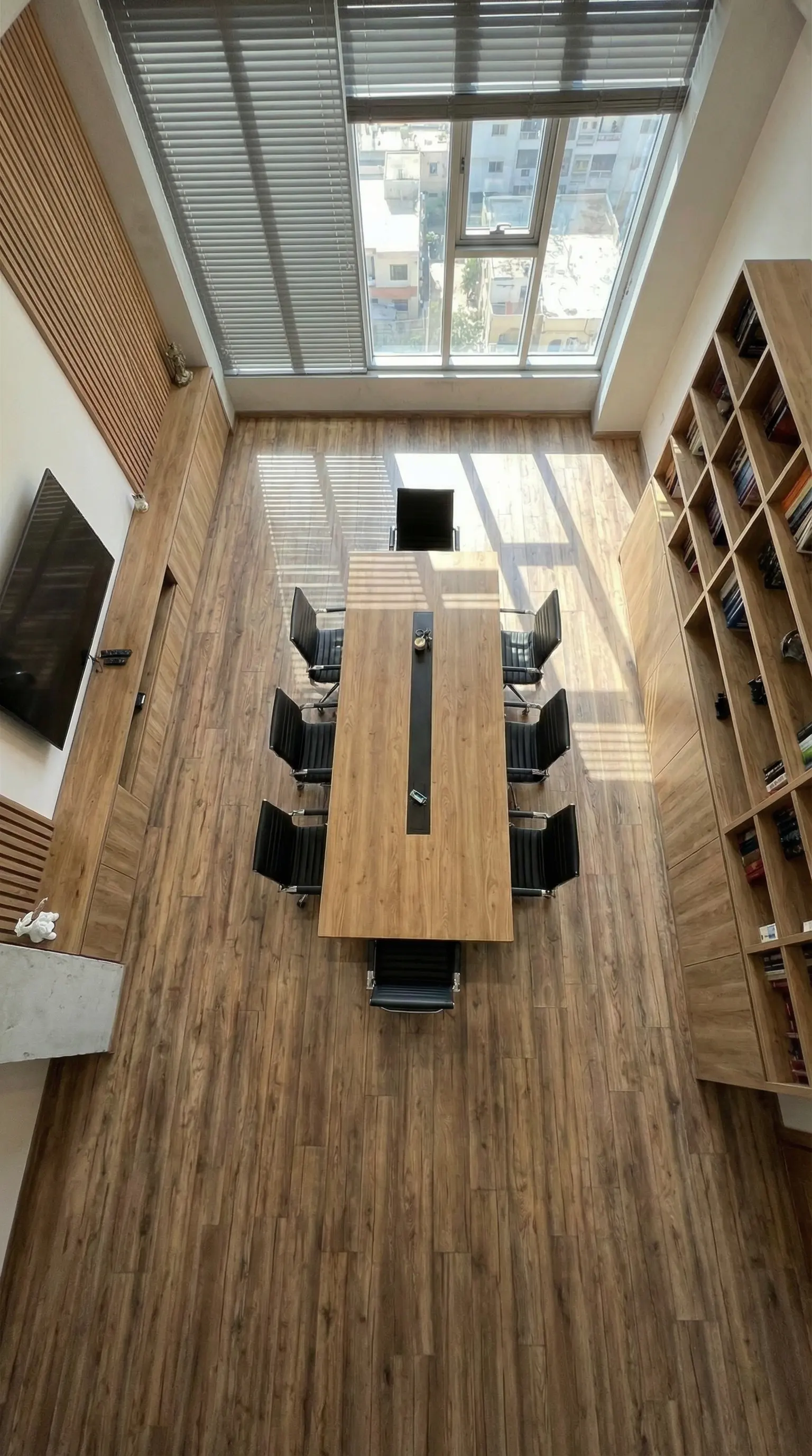Render de sala de juntas con mesa de madera vista desde arriba